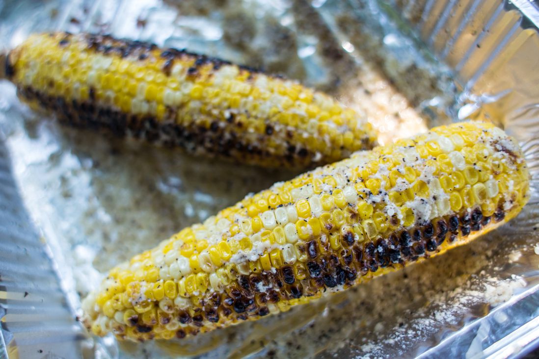 Grilled corn in salt, pepper, parmesan cheese and butter.
